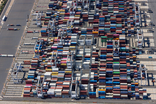 Melbourne, Australia - 07 February 2022: Aerial view of busy container harbour with stacked containers and cranes, Port Melbourne, Australia.