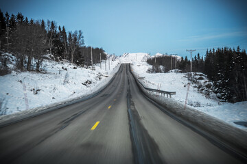 road in winter between the mountains