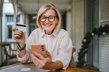 woman sit in the restaurant terrace and shop online with credit card