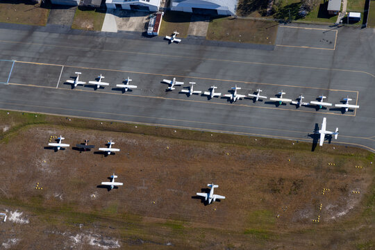 Aerial view of a busy airport with parked airplanes and a runway, Caloundra West, Queensland, Australia.