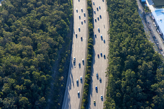 Aerial view of a scenic highway surrounded by lush greenery and traffic, Pimpama, Queensland, Australia.
