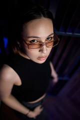 A stylish woman struts into the bar at night, exuding elegance and seduction of nightlife