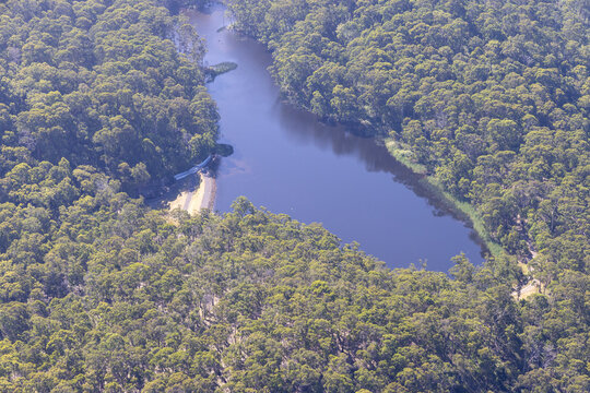 Aerial view of serene allen dame lake surrounded by lush green forest, Lorne, Victoria, Australia.