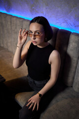 A stylish woman struts into the bar at night, exuding elegance and seduction of nightlife