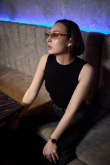 A stylish woman struts into the bar at night, exuding elegance and seduction of nightlife