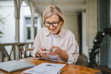 mature woman have contact less payment scan bill on mobile phone