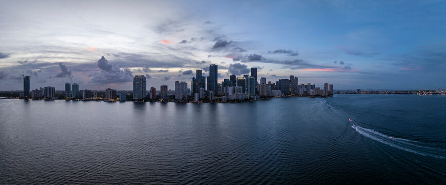 Aerial view of sunset over the modern skyline and tranquil waters of Biscayne Bay, Virginia Key, USA.