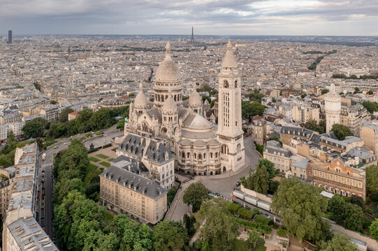 Aerial view of Montmartre hill with Basilique du Sacre-Coeur in Paris during sunset Paris, France