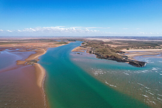 Aerial view of Nullagine River and Settlers Beach with beautiful coastline and serene blue water, Cossack, Australia.