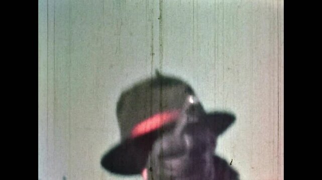 Archival film, cowboy man with revolver shooting at enemy while running, close up. Dramatically points revolver. Tense, emotional pursuit. Suspense old west movie. Vintage archive. Retro 1960s western