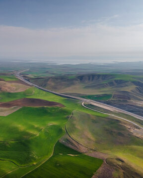 Aerial view of a serene valley with a winding road and hills surrounded by greenery, Vayvay, Turkiye.