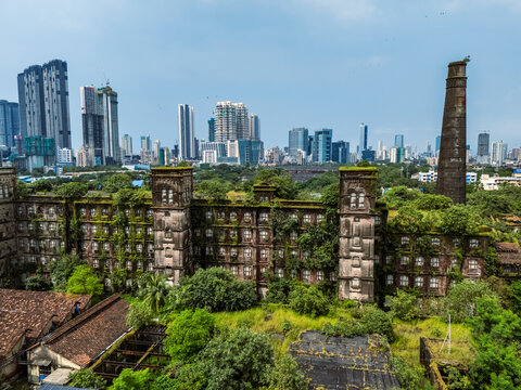 Aerial view of abandoned mill and highrise buildings surrounded by greenery, Curry Road, Mumbai, India.
