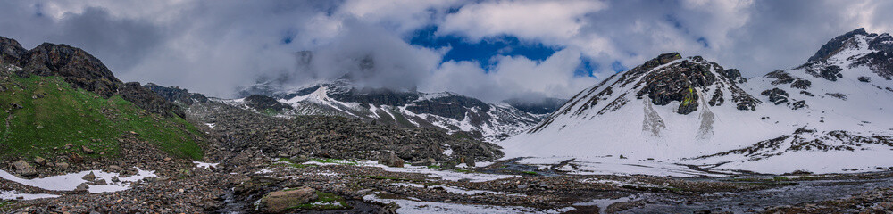 Panoramic view of glacial u-shaped valley having snow cladded peaks, glaciers and moraines  deposited by glacier en route high altitude trek 4650m in Himachal Pradesh.