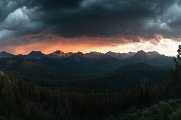 Obraz premium A mountain range with a dark sky and a bright orange sun