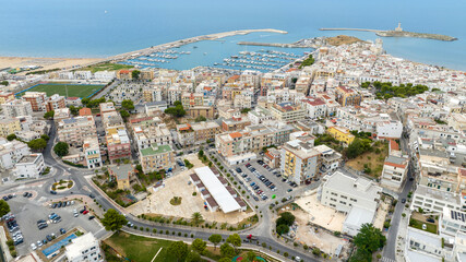 Fototapeta premium Aerial view of the tourist port of Vieste, in the province of Foggia, Puglia, Italy. It is a small marina overlooking the Adriatic Sea. In foreground is the Apulian town.