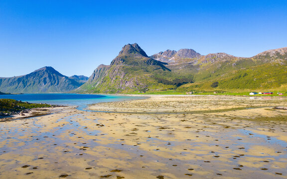 View of morpheus beach with serene water and picturesque mountains, Flakstad, Norway.