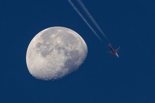 View of serene moonlit sky with airplane and contrail, Jauerling, Lower Austria, Austria.