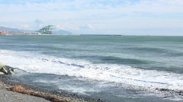 Coastal Port with Waves and Shipping Containers Under Mountains near Genoa Voltri