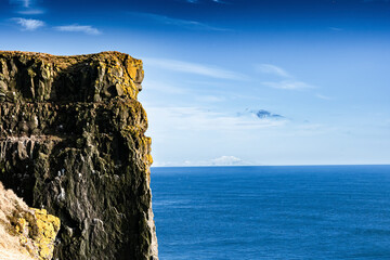 View of Lstrabjarg cliff overlooking the majestic ocean under a blue sky, Patreksfjorfur, Iceland.