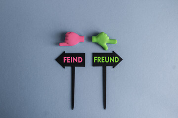 BLACK ARROW-SHAPED PLAQUES WITH THE WORDS Freund or feind in Germany. HANDS POINTING IN DIFFERENT...
