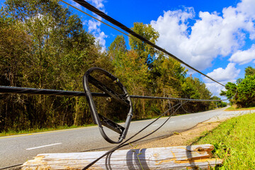 Storm damaged power lines lie broken on ground following hurricane
