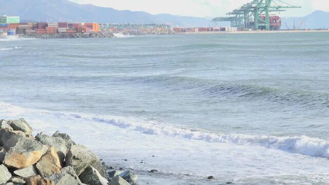 Coastal Port with Waves and Shipping Containers Under Mountains near Genoa Voltri