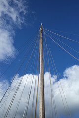 Obraz premium The mast without sails goes into the blue sky.