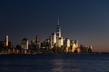 Obraz premium Stunning skyline view of New York City at dusk by the river.