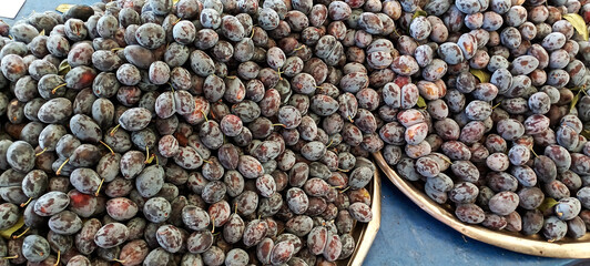 Bistritene plums exposed for sale at the fairFresh plums on a bazaar as a background