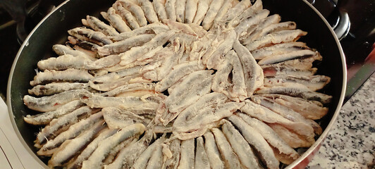 Naklejka premium fried anchovies in a frying pan, fried anchovies (TURKEY anchovies), anchovy fish, fried anchovies in a salad plate, collage from different photos of delicious seafood