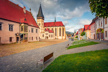 Sunny autumn view of empty street of Bardejov town with Basilica of St Giles church on background....