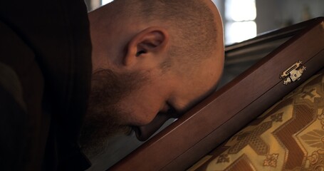 Man kissing icon on church altar, expressing deep reverence and faith. Spiritual devotion in sacred...