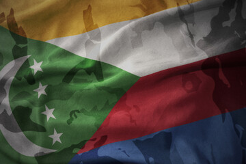 colourful waving flag of comoros on the old army khaki texture background. military concept.