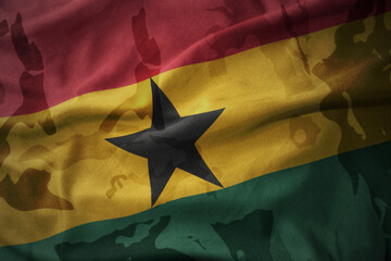 Fototapeta premium colourful waving flag of ghana on the old army khaki texture background. military concept.