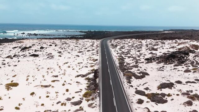Beautiful coastal road winds through white sand and rocky shores in Mojon Blanco