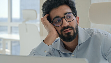 Sleepy tired Arabian Indian man businessman lazy worker employee manager working boring online job...