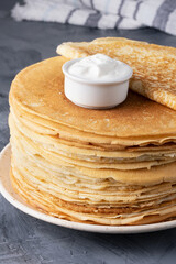 Stack of traditional russian pancakes blini on gray background. Homemade russian thin pancakes...