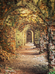 Obraz premium portrait view to brick arcs in corridors of old ruined fortress