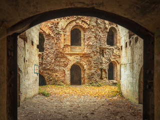 Obraz premium view under arc to windows in brick wall of old fortress