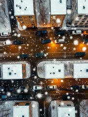 snow or haiil falls over a city street, cars and buildings. Birds eye view of an urban block with icy precipitation coming down, night, streetlights - severe weather