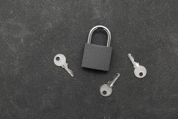 Padlock with keys on dark grunge background