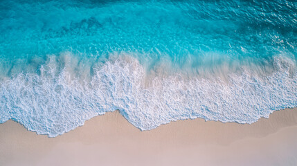 Majestic ocean waves gently crashing on pristine sandy beach shoreline aerial view