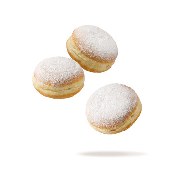 Three fresh baked donuts Berliner icing sugar powder flying isolated on white background.