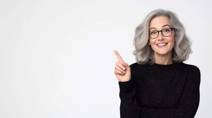 Happy mature 50s woman model pointing at copy space isolated on white background. Smiling female customer looking at camera advertising promo, presenting ads shopping offer.