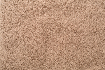Brown cuddle teddy bear fabric as background, top view