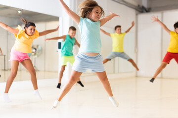 Fototapeta premium Group of positive kids jumping while dancing together in studion.