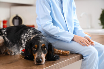 Little boy with cute cocker spaniel sitting on table in kitchen, closeup