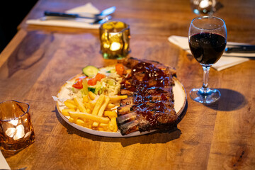 Tender grilled porterhouse or t-bone steak served with crisp golden French fries and fresh green...