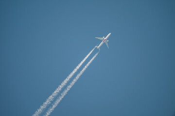 Passenger Jet with Contrails in Blue Sky