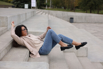 Injured woman on stairs outdoors after fall. Dangerous accident